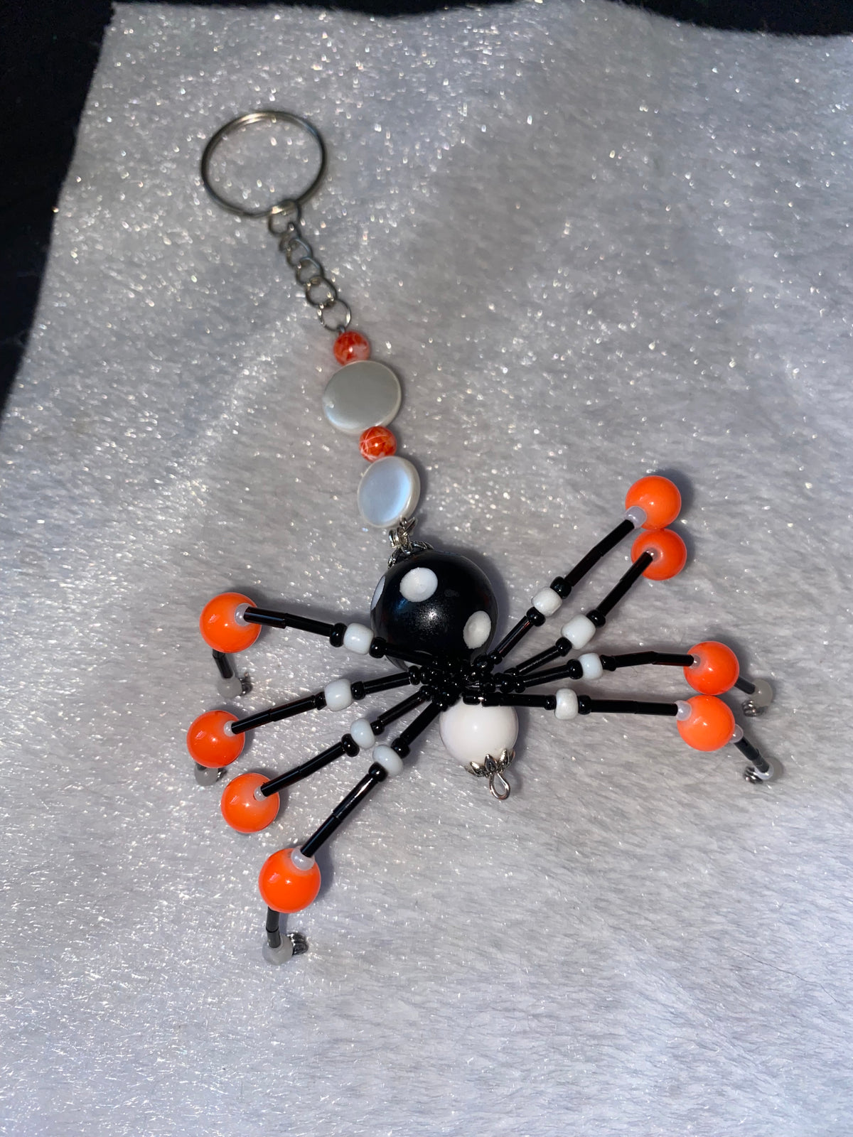 Black and white beaded spider keychain with orange accents